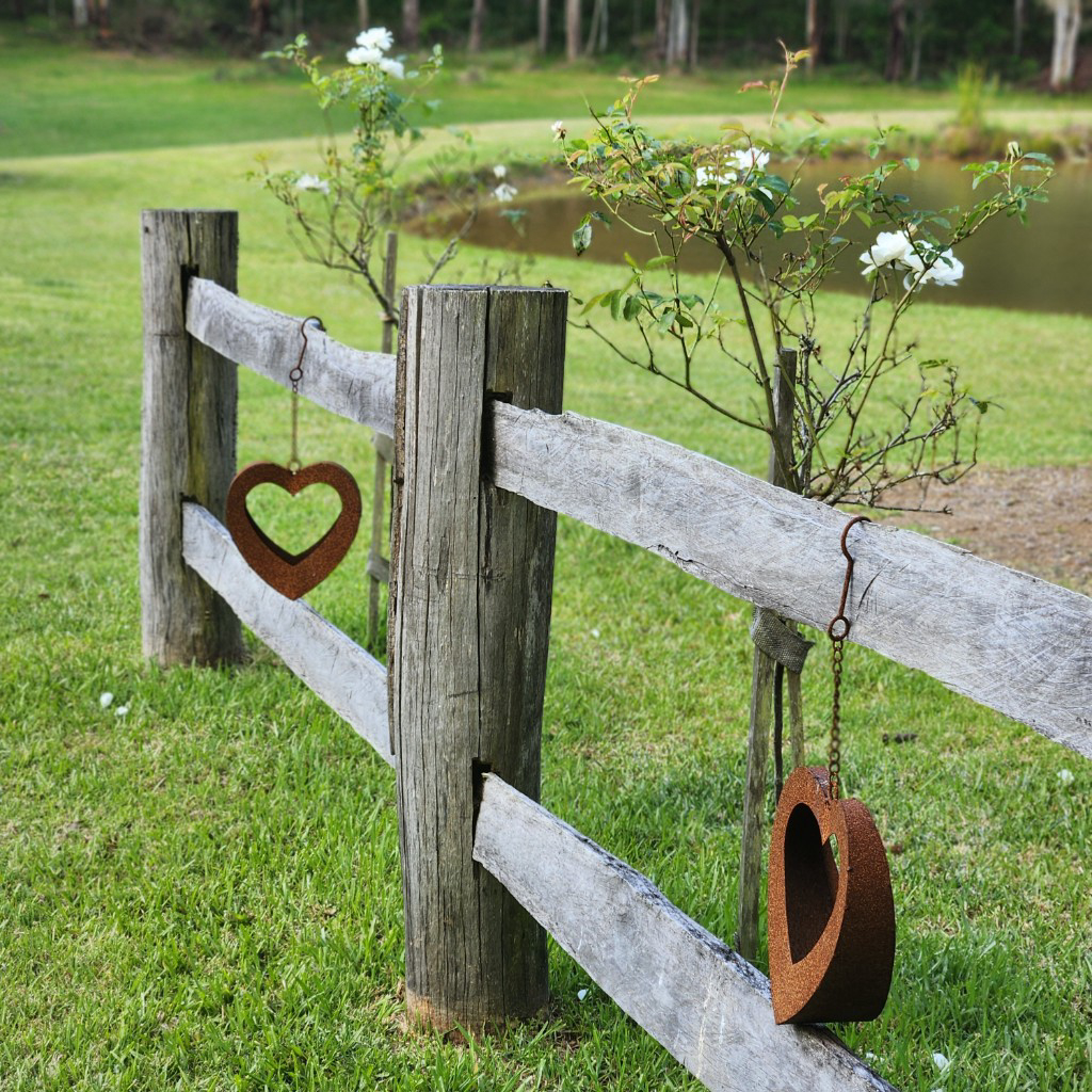 Rustic fence with heart details and white roses overlooking green paddocks in the Lower Hunter Valley